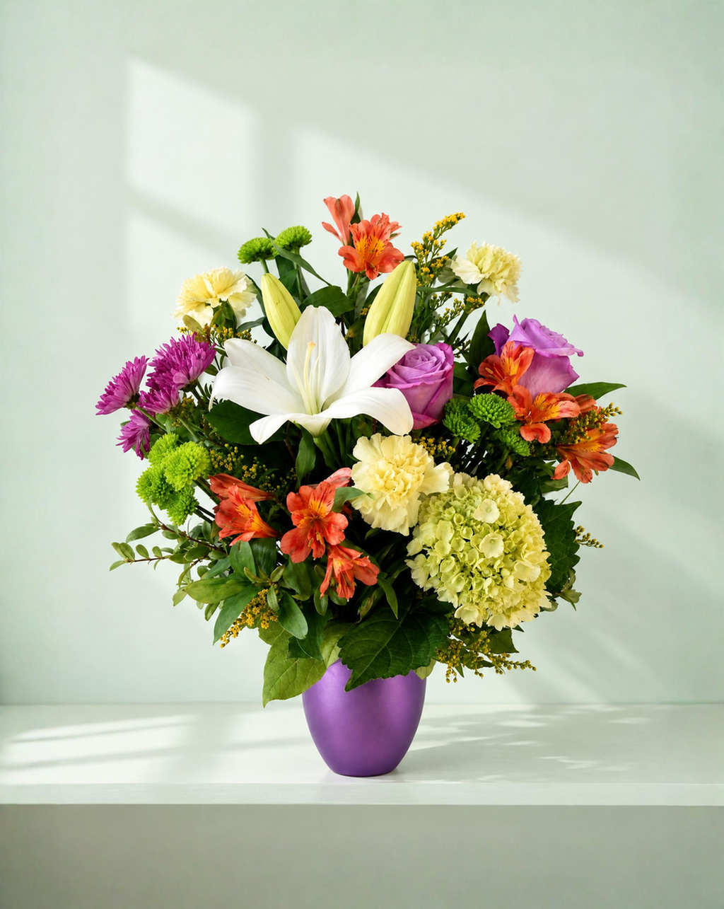 Lakewood Florist Summer Twilight bouquet featuring lilies, roses, and hydrangeas in a purple vase.