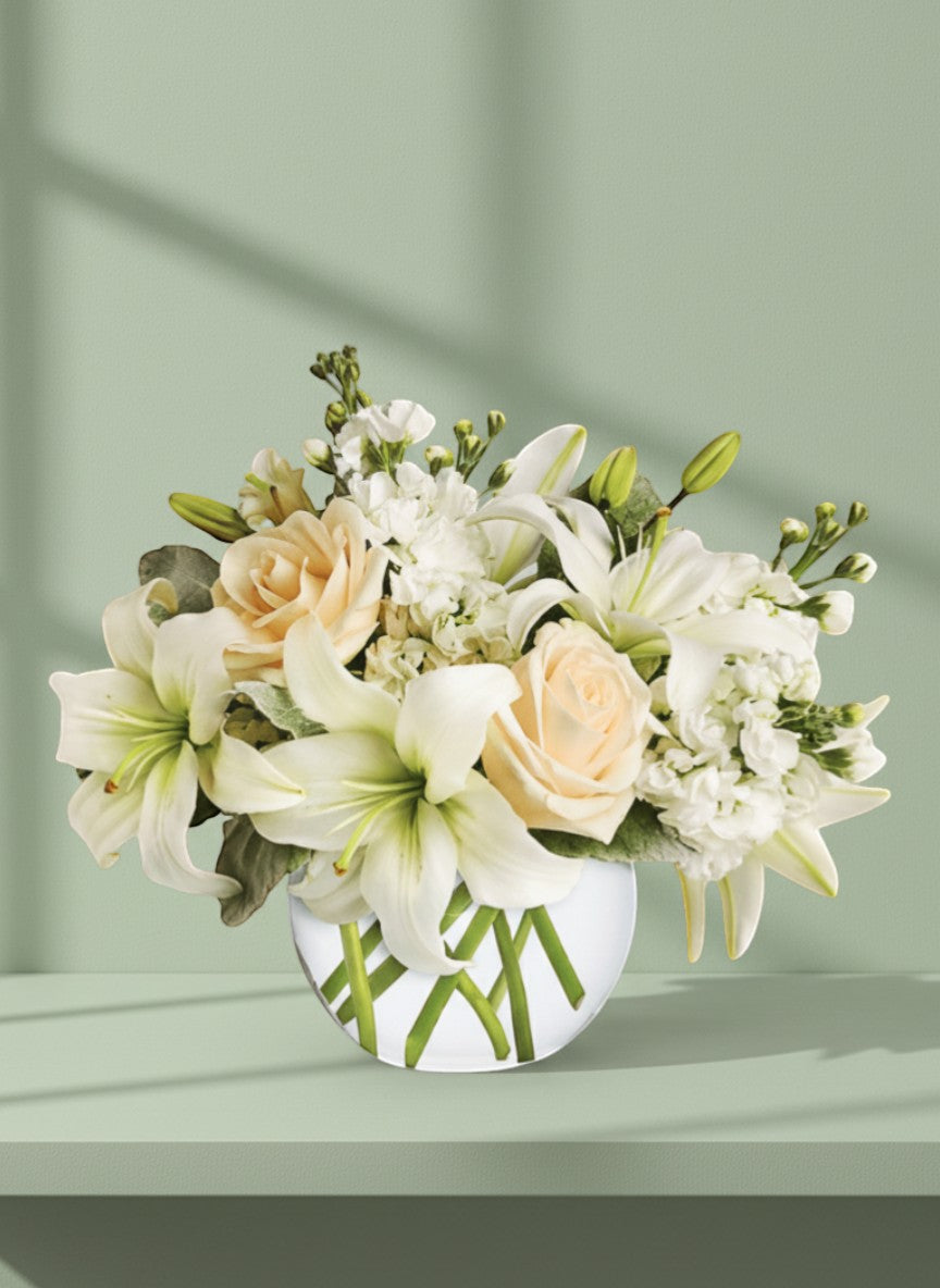 Lakewood Florist white lilies and peach roses in a low rose bowl, sympathy arrangement.